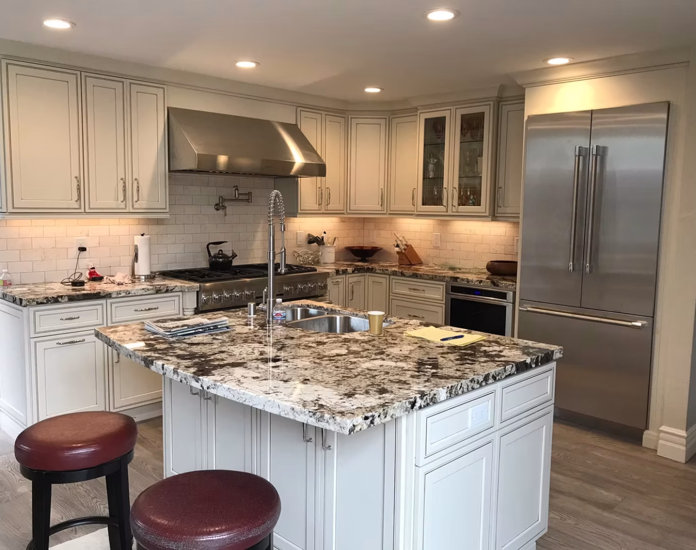 Experienced remodel team measuring kitchen walls and checking layout details before installation