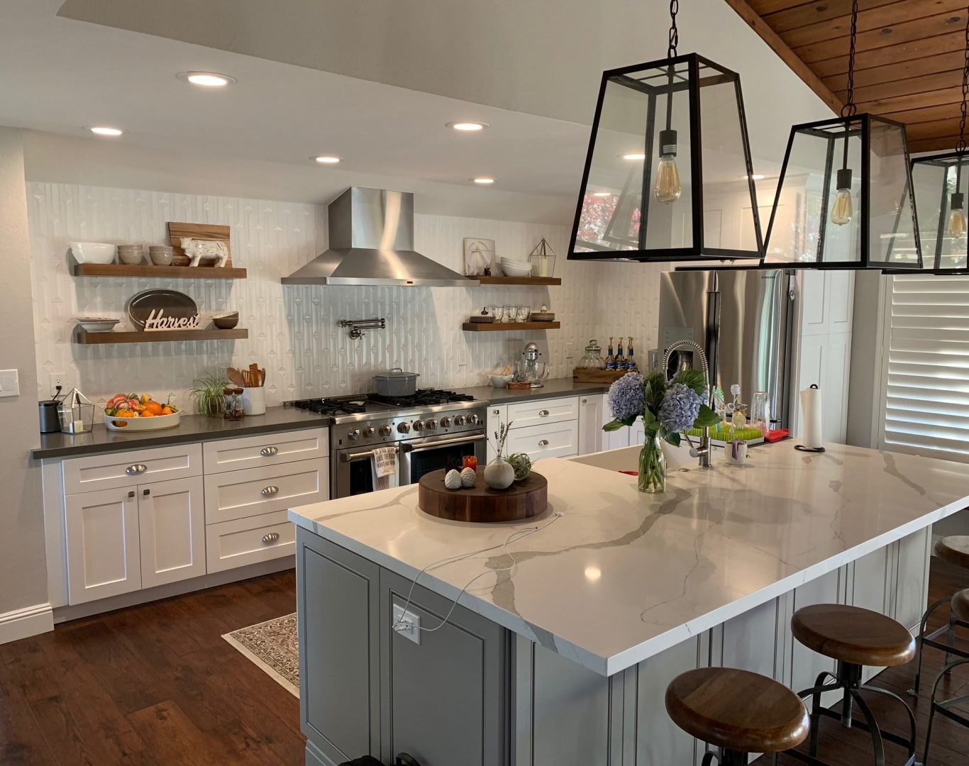 Premier Home Remodeling in San Francisco Bay Area, Skilled remodeler reviewing custom luxury kitchen plans beside premium cabinet installation, Family reviewing budget-friendly kitchen layout plans at dining table before remodel begins