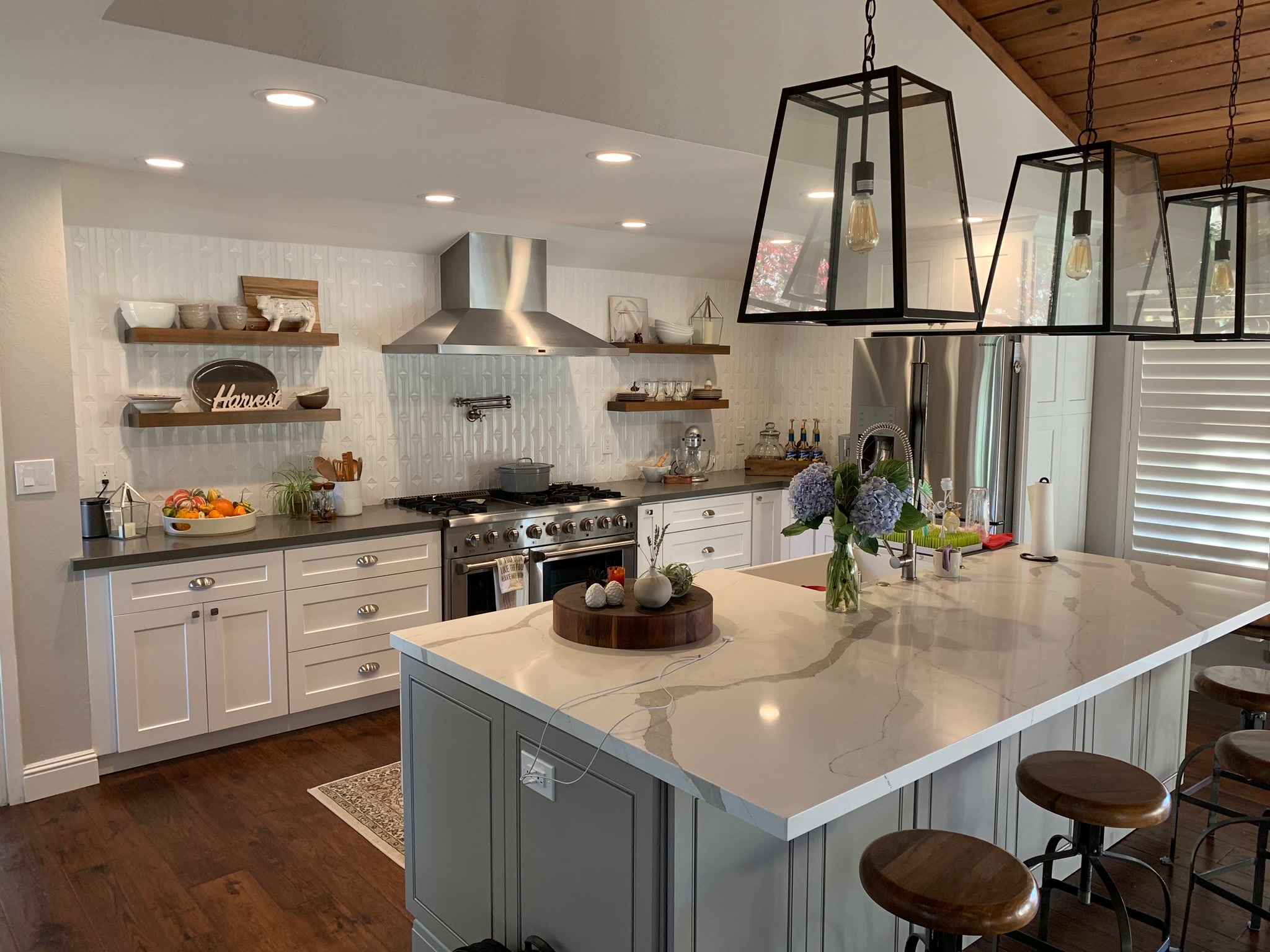 Premier Home Remodeling in San Francisco Bay Area, Skilled remodeler reviewing custom luxury kitchen plans beside premium cabinet installation, Family reviewing budget-friendly kitchen layout plans at dining table before remodel begins