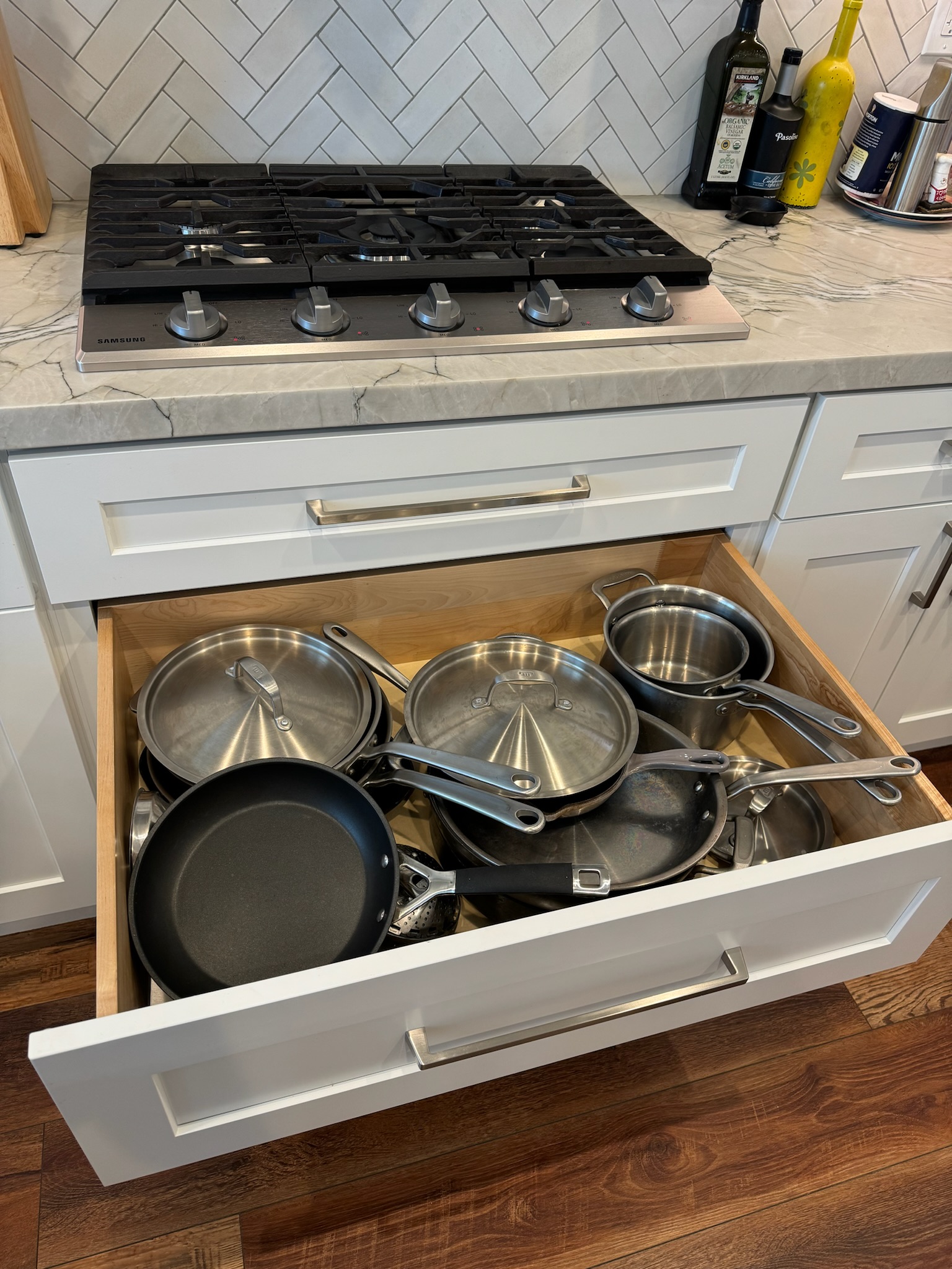 Cabinetry Services Near Me, Homeowner enjoying sleek remodeled kitchen with waterfall island and modern cabinetry, Homeowner reviewing modern kitchen cabinet samples during active Berkeley remodel consultation