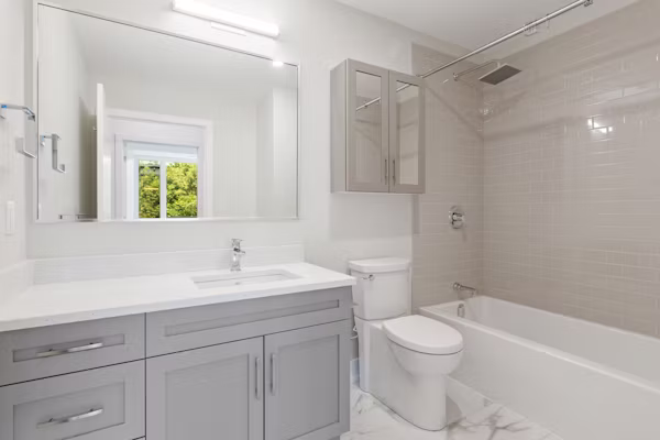 Remodeled Berkeley primary bathroom with freestanding tub, custom tile, and double vanity, Bathroom remodel specialist reviewing shower waterproofing and finish details before installation