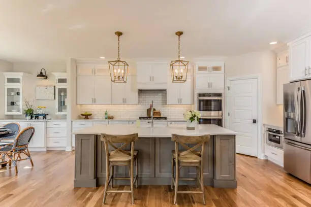 Skilled remodeler measuring kitchen workspace for updated modern layout improvements, Experienced remodeler reviewing kitchen measurements, cabinet spacing, and lighting plan